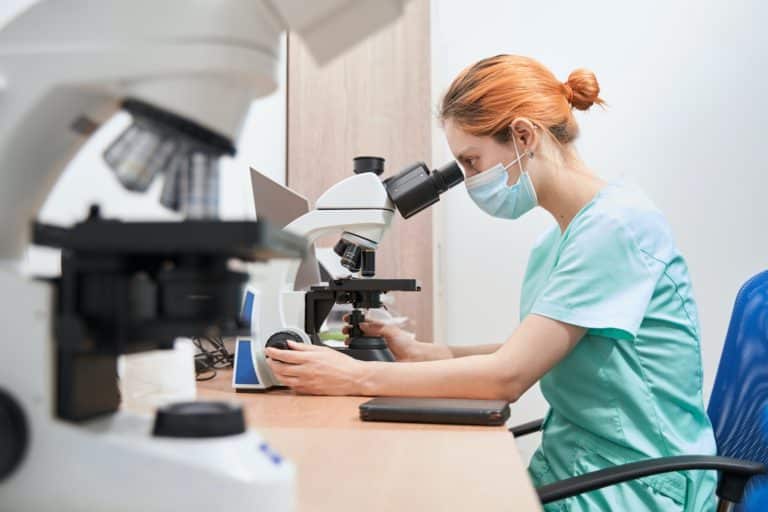 Scientist working in the hospital with microscope